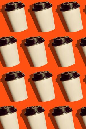 Coffee to go regular pattern made of photo on a lush lava background. Kraft paper cups with black lids and natural bright sun shadows. Lifestyle take away hot drinks concept. Trendy flatlay, top view.の写真素材