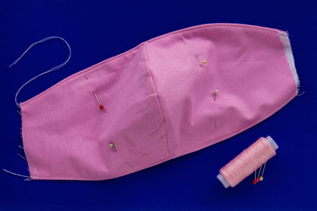 DIY sew handmade how to make cotton fabric face mask against coronavirus disease COVID-19, Do it yourself step by step photo set on blue background. Sewing machine homemade virus medical protection.の写真素材