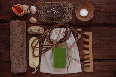 Spa wellness concept, natural coffee scrub, conifer soap in cotton eco bag, coconut shell candle, peeling sand stone,towel,wooden haircomb. Dayspa product set. Zero waste bathroom accessories flat layの写真素材