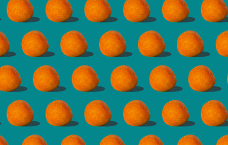 Apricot regular pattern with hard shadows flat lay on pastel turquoise background. Creative layout...