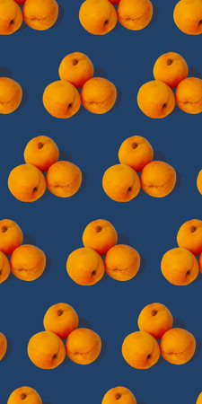 Apricot regular pattern with hard shadows flat lay on pastel blue background. Creative layout of...
