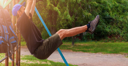 Athlete doing pull-up on horizontal bar. Male sportsman doing fitness exercises on playground...