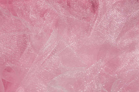 Pink tulle fabric texture top view. Coral background. Fashion color trends feminine tutu skirt flat lay, female blog backdrop for text signs desidgn. Girly abstract wallpaper, textile surface.の写真素材
