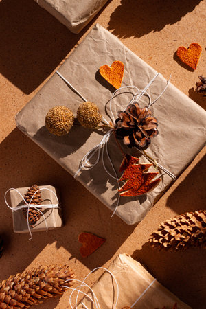 Zero waste Christmas knolling flat lay with hard shadows. Hand crafted eco gift, natural New Year jute decorations top view. Kraft paper wrapping without plastic concept. Orange zest tree, hearts, conesの写真素材