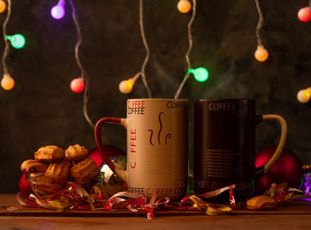 Steaming Christmas coffee cups bokeh lights decoration. Winter holidays music background, cozy home good morning concept, New year festive song. Two mugs with hot tea drink. Love romance couple date.の写真素材