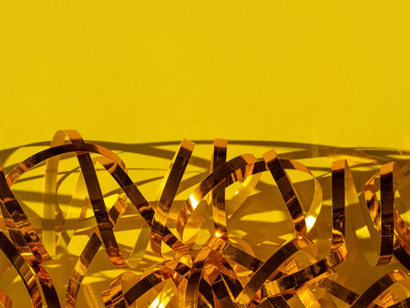 Festive yellow background Golden shimmerring shiny ribbon texture glowing decorations. Holidays New year Christmas Birthday party celebration abstract sparkle glitter Greeting card banner template.の写真素材