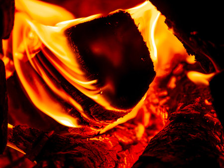 Burning firewood in rural oven. Red orange flame of wood stove in the dark. Cozy hot fireplace...