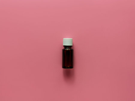 Herbal essential oil glass bottle mockup pink pastel background. Alternative medicine skin care spa...