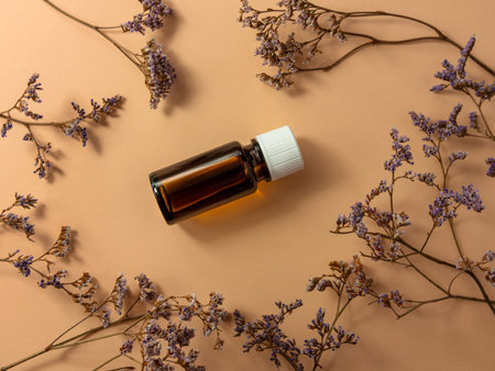 Herbal essential oil glass bottle mockup beige flower background. Alternative medicine soothing...