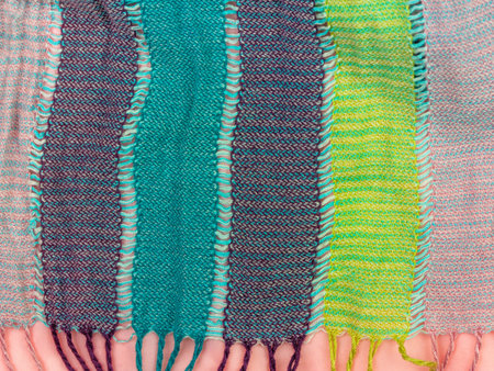 Striped knitted cotton fabric fringe texture top view. Colorful stripes knitwear background. Fashion...