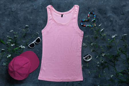 Pink cotton tank top mockup on dark background. Blank plain t-shirt template for creative design. Female summer sunglasses clothing fashion sleeveless undershirt. Casual clothes baseball cap snapback.の写真素材