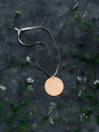 Blank engraved wooden medal mockup with white ribbon and copy space on dark background top view. Round wood tag award sport competition prize winner. Natural eco material. Template for engrave design.の写真素材