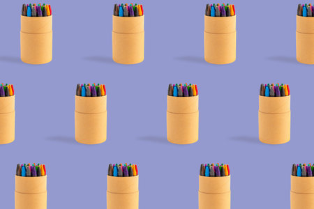 Colored crayons pattern composition on pastel purple background. Waxy pencils eco cardboard box isometric. Colorful wax pastel paper case writing art drawing. Back to school artistic education conceptの写真素材