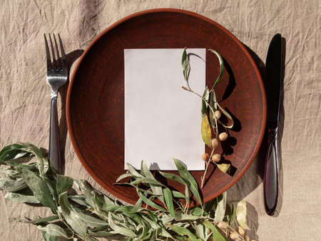 Empty craft handmade clay plate fork knife invitation mockup linen tablecloth. Table place crafted dish. Natural cottagecore tableware minimal home interior decor.Restaurant food countryside aestheticの写真素材