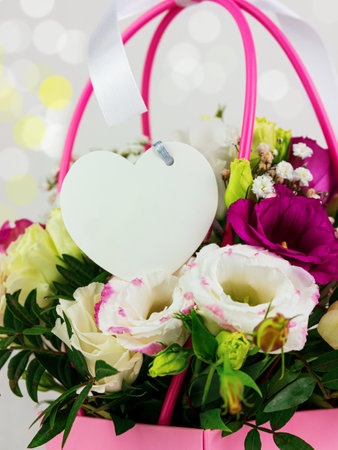 Beautiful white Eustoma Gypsophila flowers bouquet in pink pastel basket light background. Floral gift blooming wallpaper, Womens Mothers day greeting card wedding invitation Festive banner copy spaceの写真素材