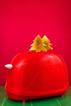 Red toaster crispy fresh toast fir tree shape on green tile. Breakfast food. Morning bread slice sandwich cooking creative minimalism idea Christmas sale Kitchen Appliances background in minimal styleの写真素材