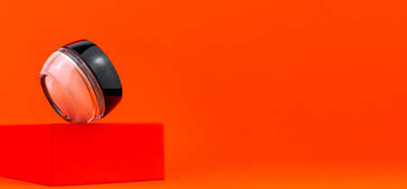 Cosmetic tonal foundation glass jar mockup on geometrical podium orange background. Balancing makeup product Smooth BB liquid cream facial skin. Skintone correction. Modern minimal presentation Bannerの写真素材