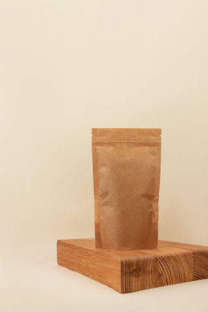 Pouch bag mockup on wooden podium neutral beige background monochrome. Blank brown kraft paper pack...