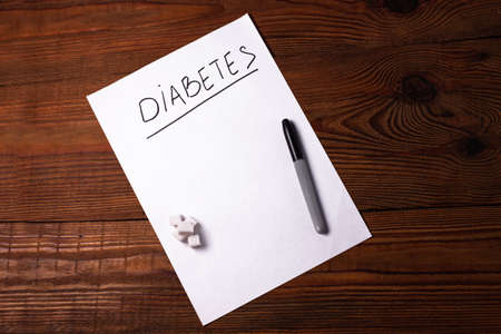 Stop Diabetes sign on a white paper sheet with sugar cubes on wooden background, World diabetes day November 14. Prevent disease before it begins,detection diagnosis, clinical researches,patients listの写真素材