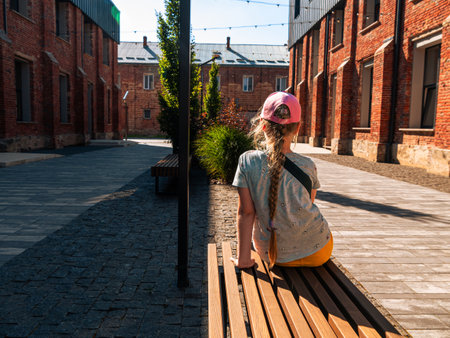 Child girl rests in modern cafe in loft style Break-out area red brick walls Old buildings renovation Workspace exterior. Creative urban space city brickwork warehouse design floor-to-ceiling windows.の写真素材