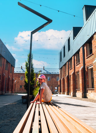 Child girl rests in modern cafe in loft style Break-out area red brick walls Old buildings renovation Workspace exterior. Creative urban space city brickwork warehouse design floor-to-ceiling windows.の写真素材
