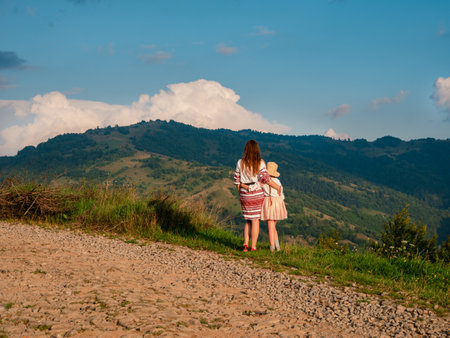 Ukrainian women in authentic costumes Mother and daughter in embroidered shirts standing on beautiful Carpathian Mountains peak scenic view. Independence day of Ukraine Zakarpattya Local travel Europeの写真素材