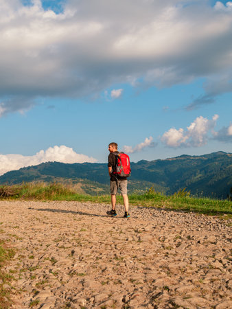 Millennial man hiking with backpack Carpathian Mountains road climbing peak scenic view. Travel Lifestyle wanderlust adventure vacations Bearded guy walking outdoor alone into the wild Ukraine, Europeの写真素材