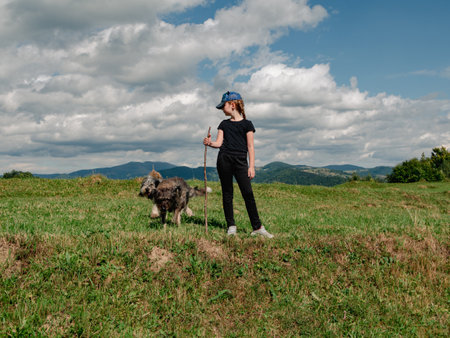 Little girl with dogs Carpathian mountains peak in Zakarpattya village Ukraine Europe. Family walks with pets on scenic landscape green trees sunny day Eco Local countryside tourism Hiking Cottagecoreの写真素材