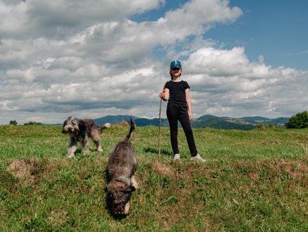 Little girl with dogs Carpathian mountains peak in Zakarpattya village Ukraine Europe. Family walks with pets on scenic landscape green trees sunny day Eco Local countryside tourism Hiking Cottagecoreの写真素材