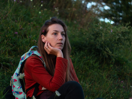 Portrait of thoughtful caucasian brown hair woman sitting outdoor in silent forest alone looking away. Thinking pensive melancholic serious girl Authentic people Candid emotion real life Mental healthの写真素材