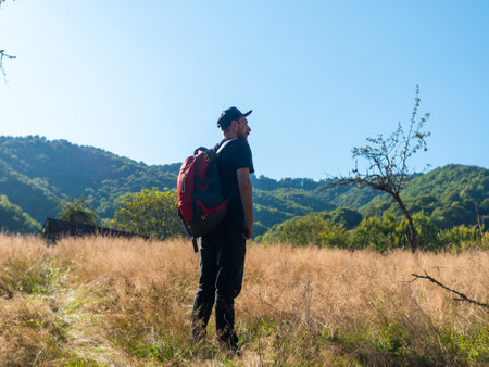 Millennial man hiking with backpack Carpathian Mountains road climbing peak scenic view. Travel Lifestyle wanderlust adventure vacations Bearded guy walking outdoor alone into the wild Ukraine, Europeの写真素材