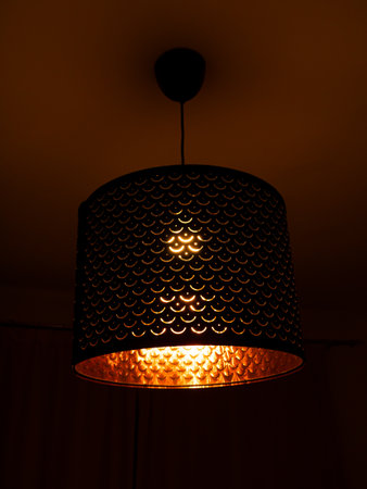 Single Pendant lamp bronze metal ornament pattern. Classing ceiling lighting lamp with metal cage glowing warm light Cylinder Lampshade. Modern interior. LED Light Decoration For Bedroom, Living Room.の写真素材