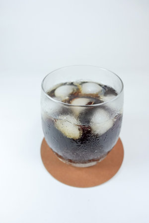 Cola in glass with ice, close up