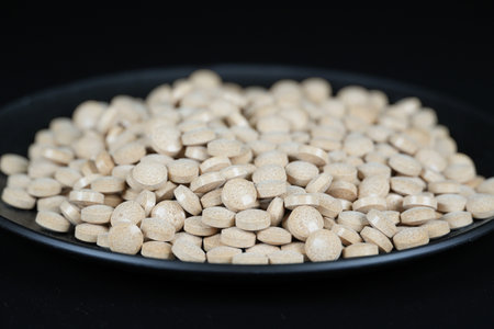 Supplement brown tablet black backgroundの写真素材