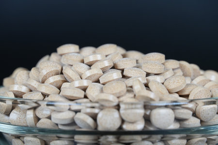 Supplement brown tablet black backgroundの写真素材