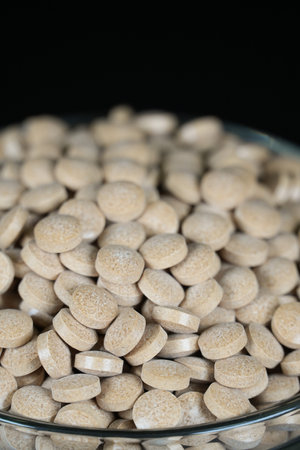 Supplement brown tablet black backgroundの写真素材