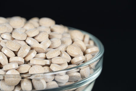 Supplement brown tablet black background