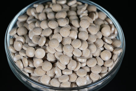 Supplement brown tablet black backgroundの写真素材