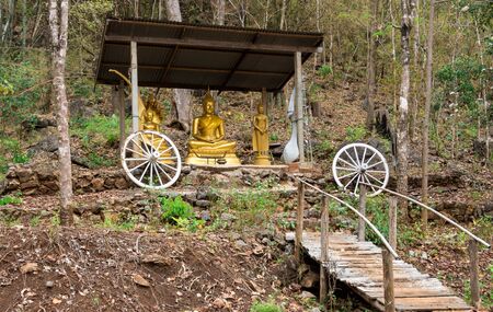 The Buddha is in the middle of the forest on the mountain and has a wooden bridge for the walk to worship.の写真素材