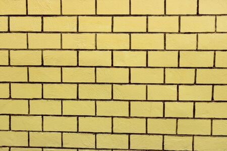Abstract wallpaper texture stone yellow brick. Pattern on wall for abstract background. The yellow wall is divided into several small compartments.の写真素材