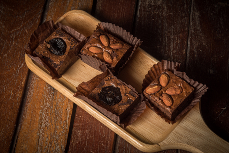 Chocolate Cake There is a sprinkle of nuts on a wooden plateの写真素材