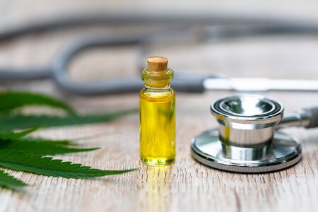 Hemp oil bottle Medical stethoscope And the leaves of cannabis Placed on the table. Concepts of alternative medicine, treatment of diseases. The invention of natural herbs as a treatment medicine.の写真素材