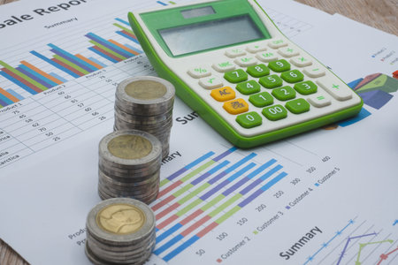 A pile of coins and a calculator placed on a graph Financial chart Business growth, finance,...