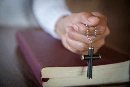 Bible and crucifix. A young woman asks blessings from God with the power and power of holiness,...