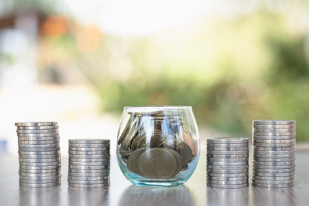 A coin in a glass jar placed on the table and a coin ladder Business growth concept Saving money in...