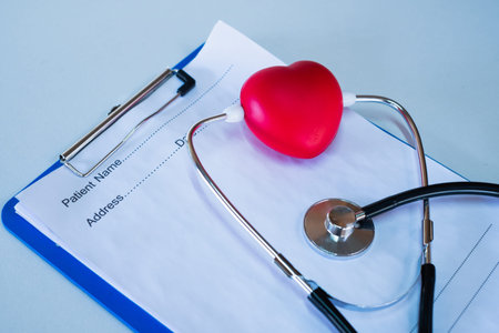 Red heart medical stethoscope and black pen Put on the doctor's charging plate.Health examination...