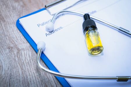 Doctor's prescription, stethoscope and hemp oil in a glass bottle, alternative medicine concept Herbal treatment and treatment. Medical marijuana research.の写真素材