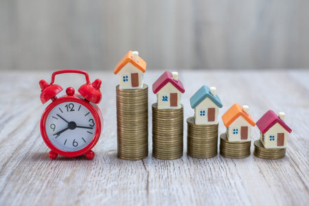 Coin ladder.Stacking coins on desk with clock. Finance and money concept.Stacked coins to save for...