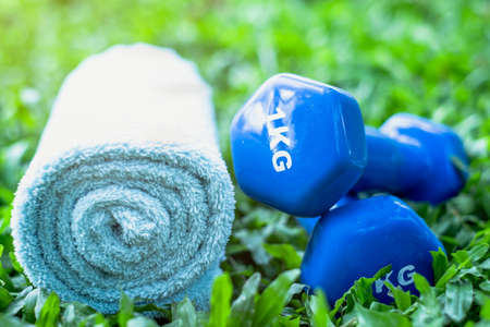 Dumbbells and towels on the grass. Breathe the fresh air from nature An essential tool of sporting activities. Healthy lifestyle, lose weightの写真素材