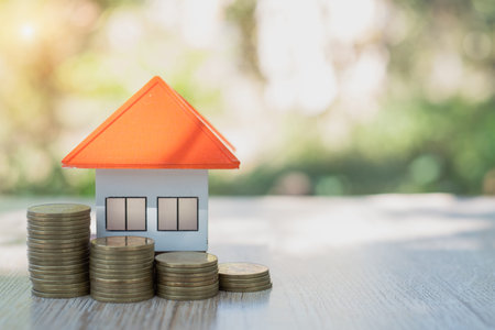 Orange roof house model. Coins that are stacked from low to high. Financial and banking concepts Preparing for home purchase and real estate economic growth. Home mortgage finance.